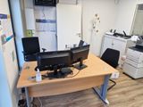 un bureau sur lequel se trouvent deux écrans d'ordinateur et une imprimante