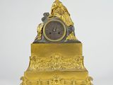 a gold clock with a statue on top of it