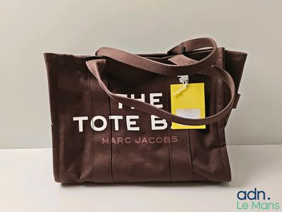Le sac fourre-tout est marron et comporte une étiquette jaune.