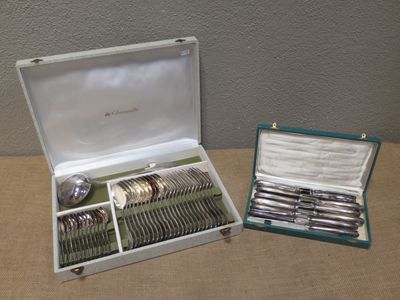 a box with silverware on a table next to a pair of spoons