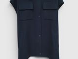 une chemise noire suspendue à un cintre sur un mur blanc