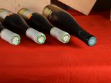several bottles of wine are lined up on a red table cloth