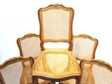 six chairs and a table in a room with a white wall