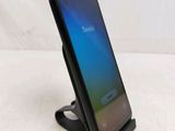 a close up of a cell phone on a stand on a white surface