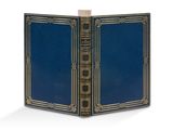 un livre ouvert, avec une couverture bleue et des bordures dorées