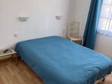 a bed with a blue comforter in a small room