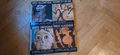 trois livres posés sur un parquet, avec un parquet en arrière-plan