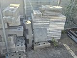 a pile of concrete blocks on the ground next to a fence