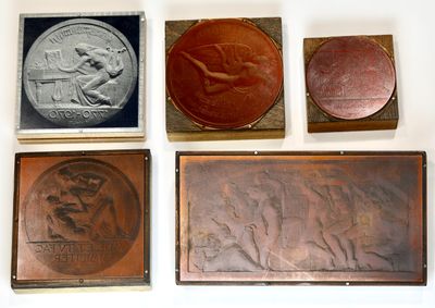 four different types of metal plaques on a white surface