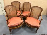 quatre chaises anciennes à dossier en rotin, avec des coussins orange