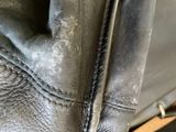 a close up of a black leather bag with a zipper