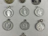 several silver and gold medals are displayed on a white surface