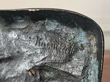 a bronze statue of a man sitting on a bench
