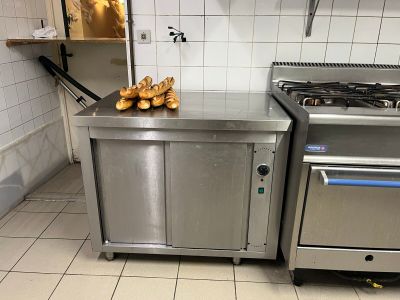 une cuisine équipée d'une cuisinière, d'un four et d'un tas de baguettes posées sur le plan de travail