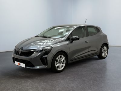 Une voiture grise est garée dans une pièce au sol noir.