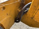 a close up of a yellow bulldozer with a spider web attached to it