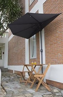 une table et des chaises à l'extérieur d'un bâtiment, surmontées d'un parasol