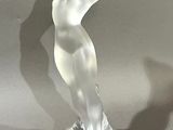 a glass sculpture of a woman standing on a base