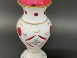 a white vase with a red and gold decoration on it
