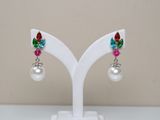 pair of multicolored crystal and pearl earrings on a white stand
