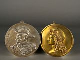 two gold medals with a woman ' s face and a man ' s head