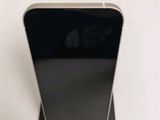 a black clock on a metal stand on a white surface