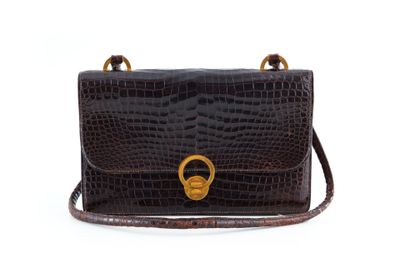 un sac à main en cuir de crocodile marron, orné d'un anneau doré sur la poignée