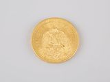 a close up of a gold coin on a white surface
