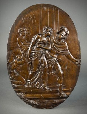 a bronze plaque depicting a woman and two men on a stage