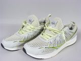 Les chaussures de course blanches et jaunes sont posées sur une surface blanche