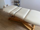 a massage table that is sitting on a wooden stand
