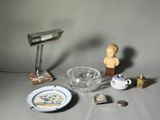 une table sur laquelle se trouvent une assiette, un bol, une lampe et d'autres objets