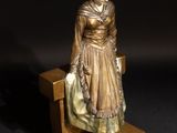 a figurine of a woman sitting on a bench
