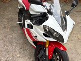 une moto rouge et blanche garée sur un parking