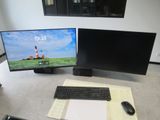 a computer desk with two monitors and a keyboard