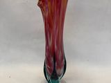 un vase en verre posé sur un socle, sur une table