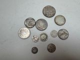 several silver coins are arranged on a white surface