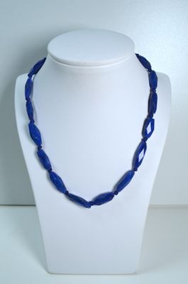 un gros plan d'un collier orné de perles bleues sur un mannequin
