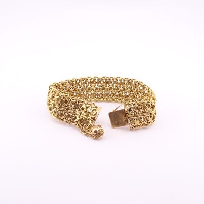 gros plan d'un bracelet en chaîne en or sur fond blanc