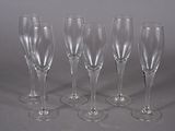 four empty wine glasses are lined up on a gray surface