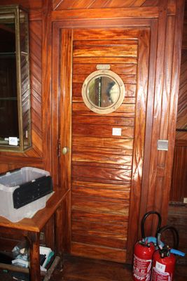 une pièce avec une porte en bois et un miroir accroché au mur