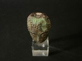a close up of a stone head on a clear stand