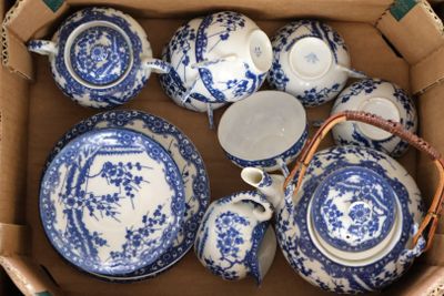 de nombreuses assiettes et tasses bleues et blanches dans une boîte