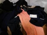 a person that is laying on a bed with clothes on it