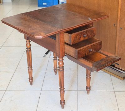une petite table avec un tiroir en dessous, posée sur un sol carrelé