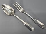 two spoons and a fork sitting on a table next to each other