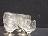 four wine glasses sitting on a table with a black background