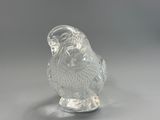 a glass figurine of a bird on a stand