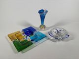 a blue glass vase and a blue plate on a white table