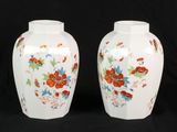 two vases with flowers painted on them on a black background